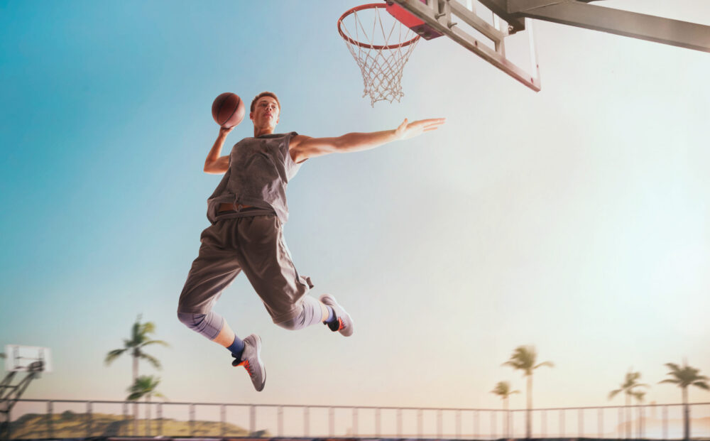 Streetball. Basketball player in action on sunset.