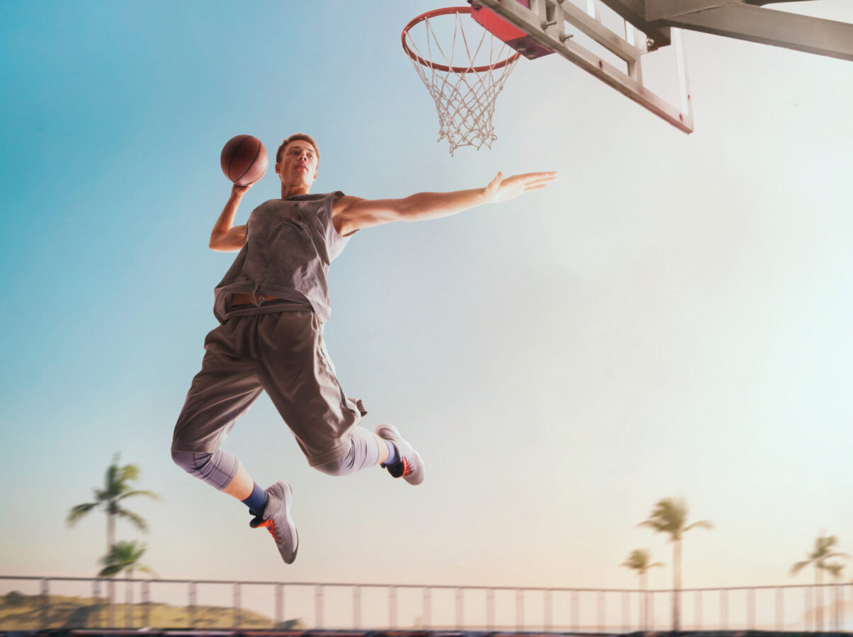 Streetball. Basketball player in action on sunset.